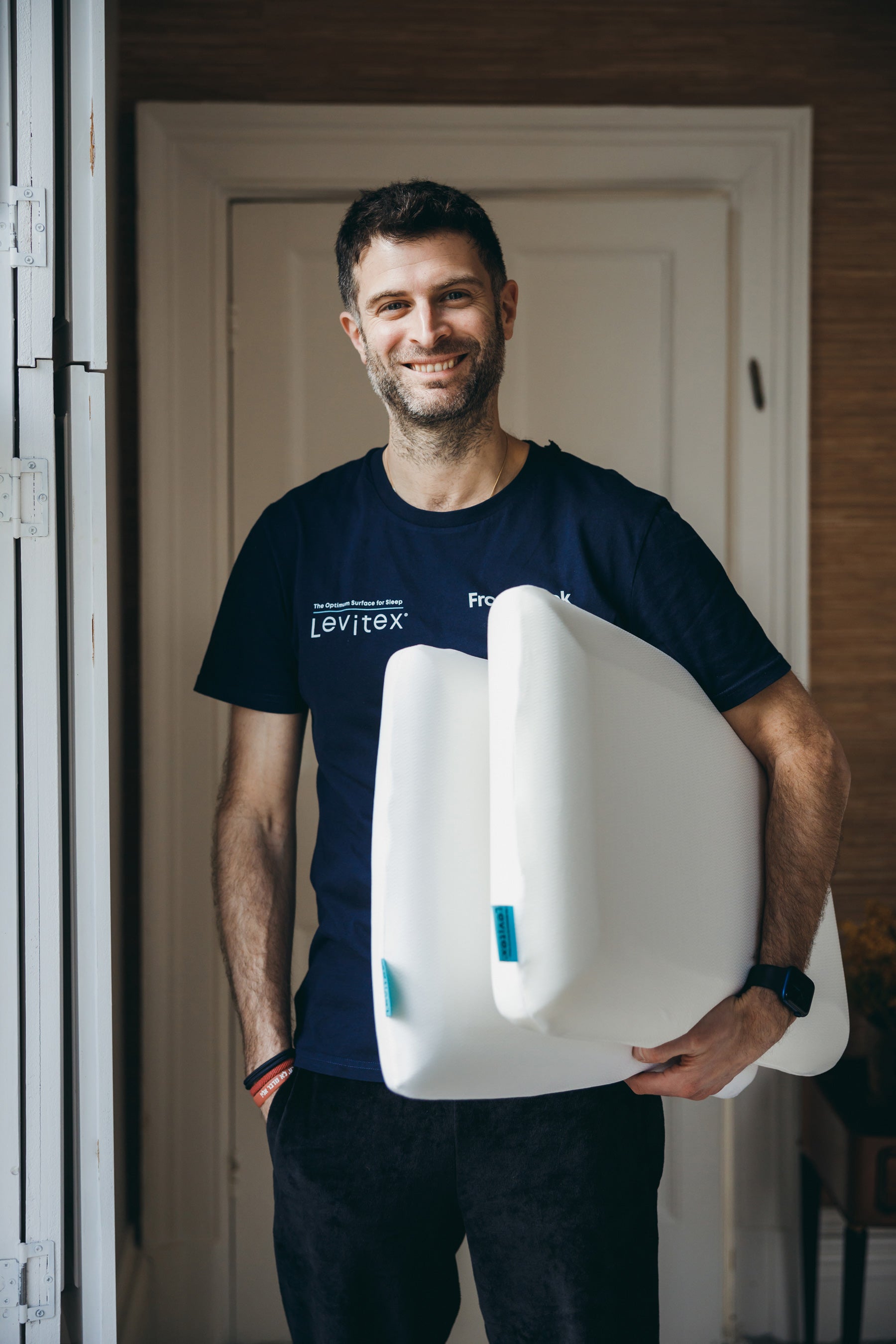 James Leinhardt holding 2 pillows in his left arm