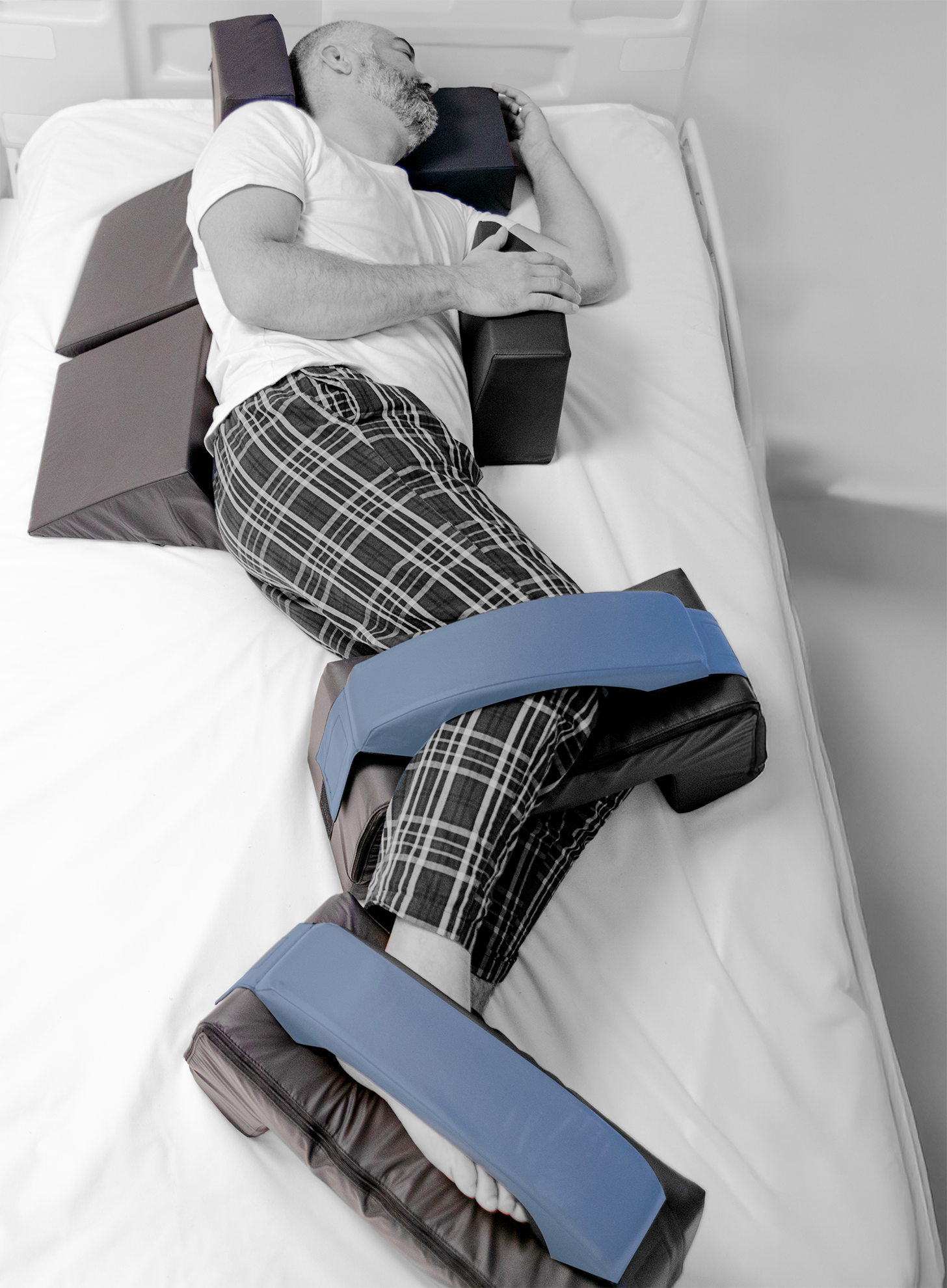 Person lying on a medical device with adjustable straps in a clinical setting