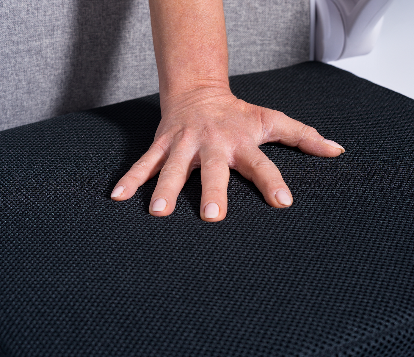 hand pressing on a seat topper