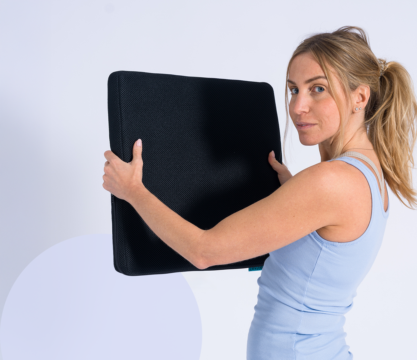 woman holding the seat topper in front of her while being turned to the camera