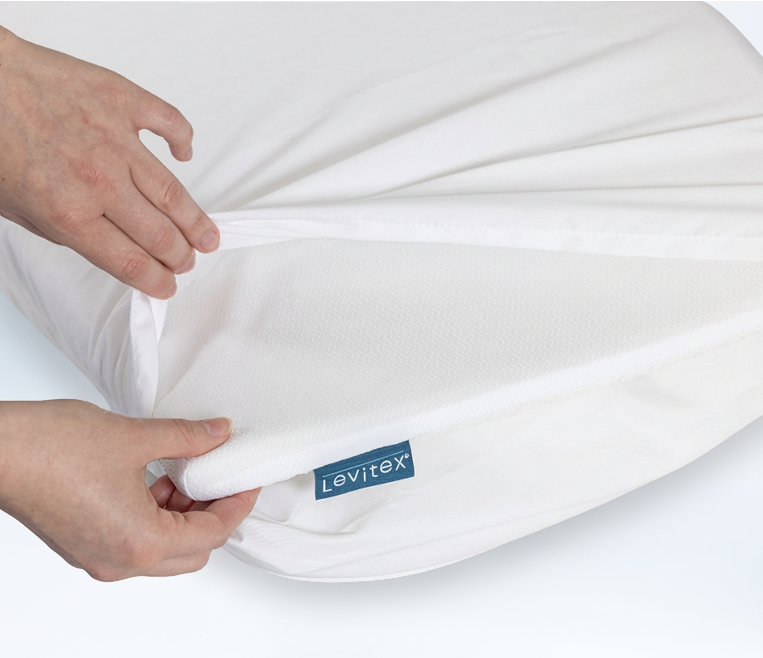 Person opening up pillowcase to reveal Slice pillow topper on top of a regular old pillow