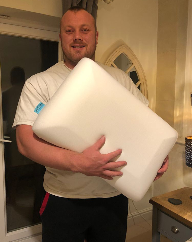 adam bishop holding a levitex pillow