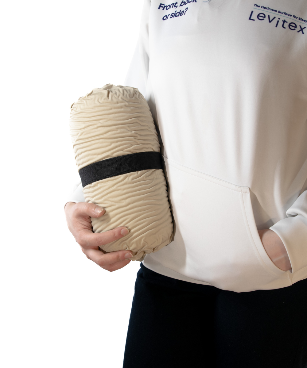 woman holding up a folded up pillow